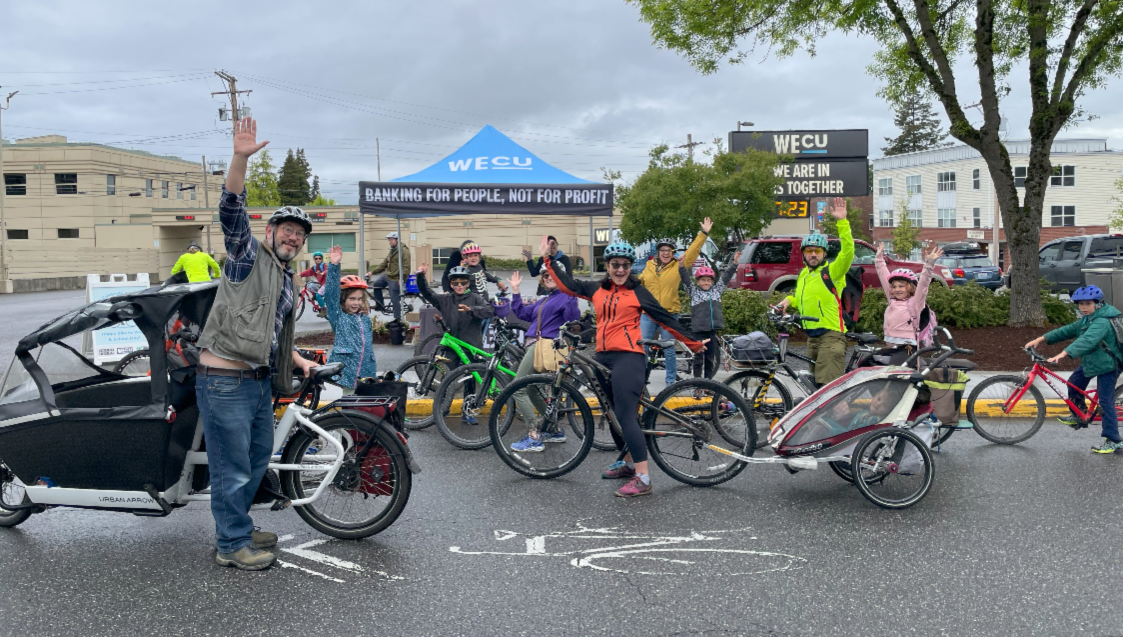 Group of people on bikes at an event waving